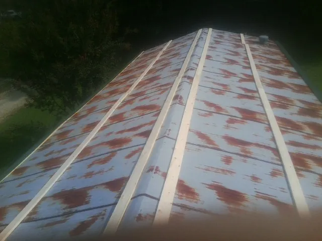 Rusted metal roof panels with new wood purlins before replacement — Storm Damage Roof Repair in Sanbornville by Roofing Brothers