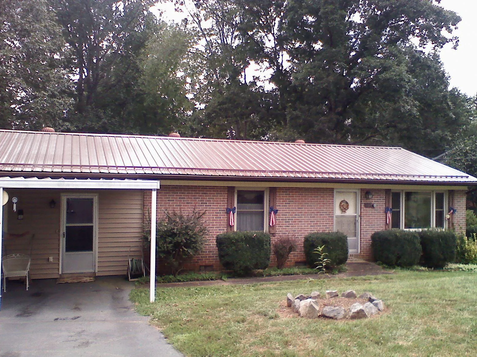 Bronze metal roof and carport on a brick ranch home — Roof Repair work by our crew in Sanbornville